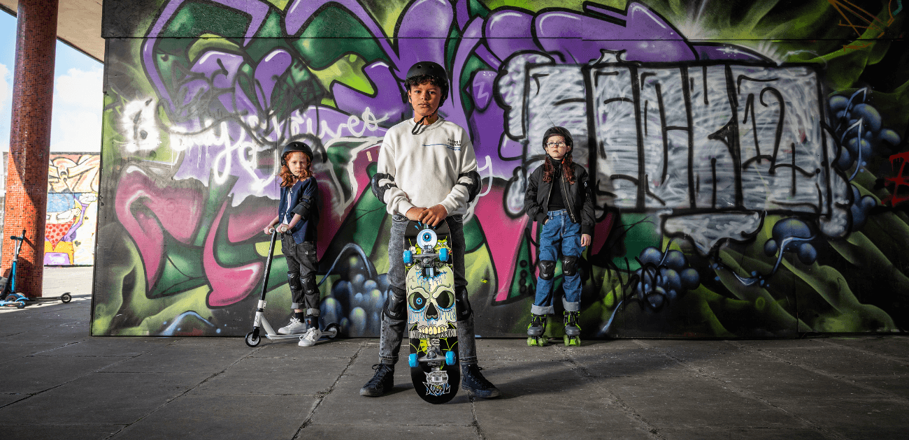 Children playing outside with Xootz scooters, roller skates, and skateboards - promoting active outdoor play.