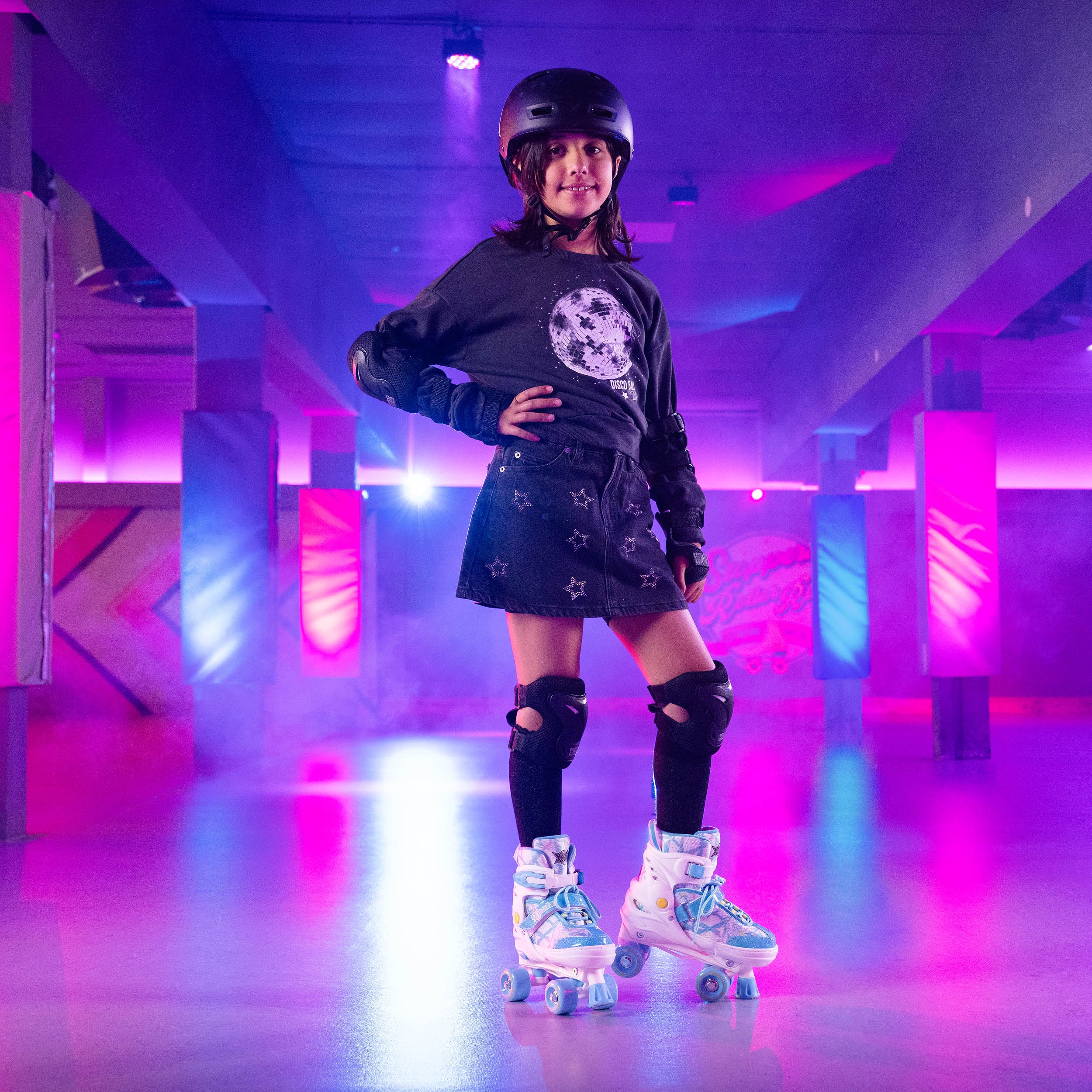 Kid wearing roller skates and protective gear in a neon-lit indoor setting