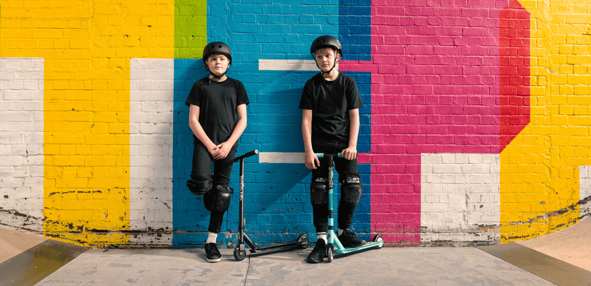 Two boys riding scooters in a skate park, showing the fun and benefits of scooting.