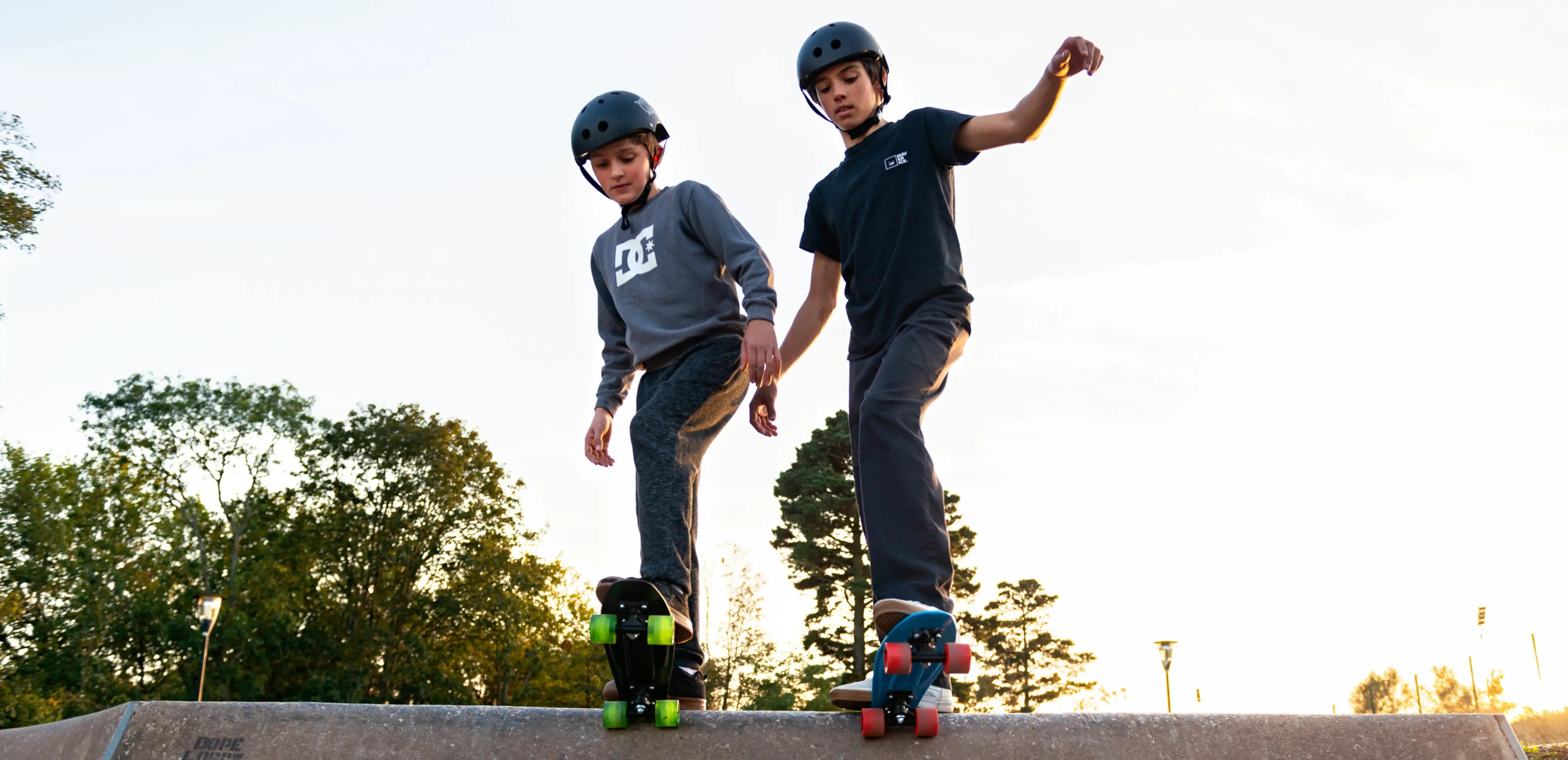 Two boys at skate ramp preparing to ride down on skateboards, showing active outdoor play that supports kids’ mood, sleep, and focus.