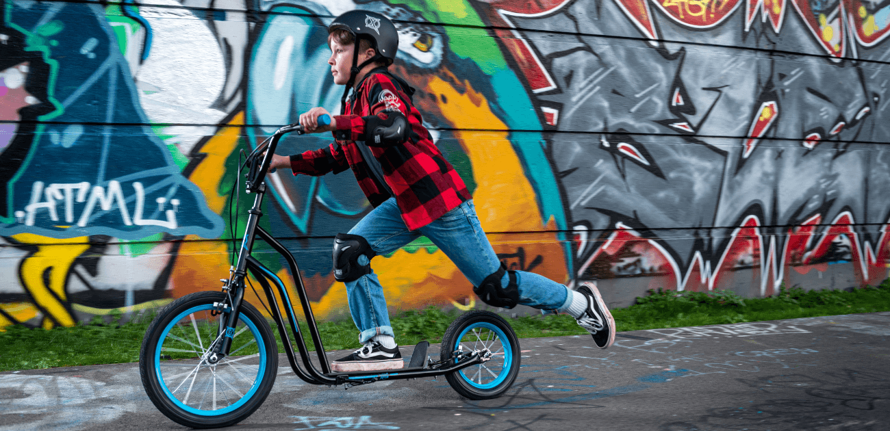 Child riding a BMX scooter outdoors promoting mental health benefits.