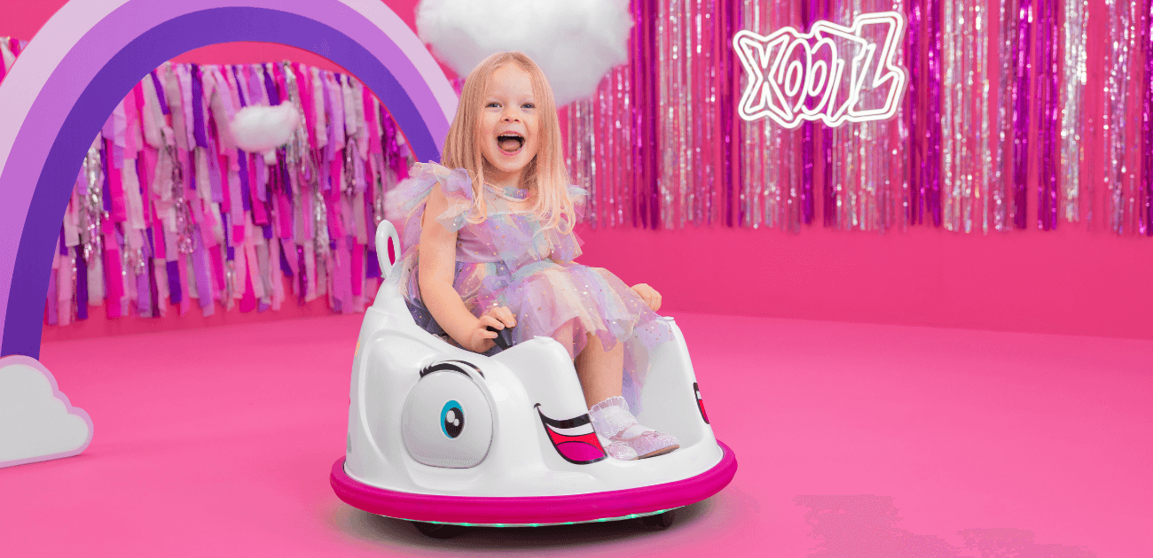 Girl on a unicorn electric bumper car - a fun and colourful ride-on toy for kids.