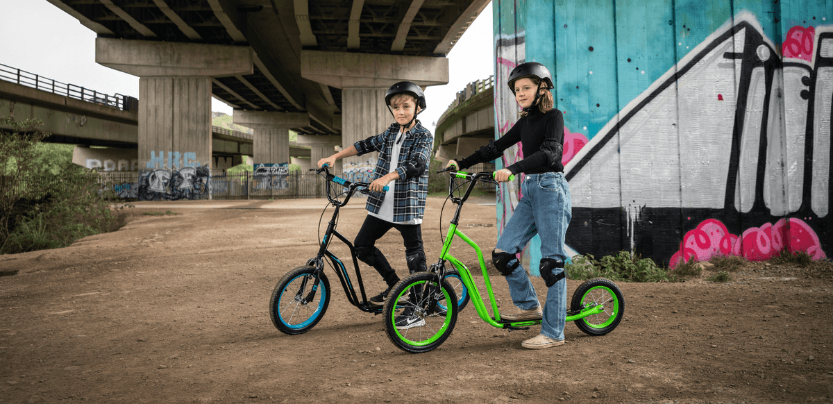 Two kids riding BMX scooters outdoors, showing the benefits of active outdoor play.
