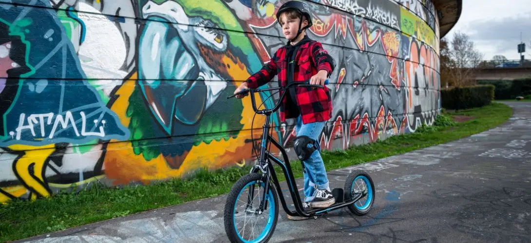 young boy riding a blue bmx scooter to school